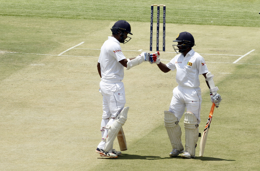 Sri lankan cricket players Dimuth Karunaratne, left, and Kaushal Silva touch gloves during a test match against Zimbabwe since 2004, at Harare Sports Club in Harare, Saturday, Oct, 29, 2016. Zimbabwe is playing host to Sri Lanka in its 100th test cricket match in Harare(AP Photo/Tsvangirayi Mukwazhi)