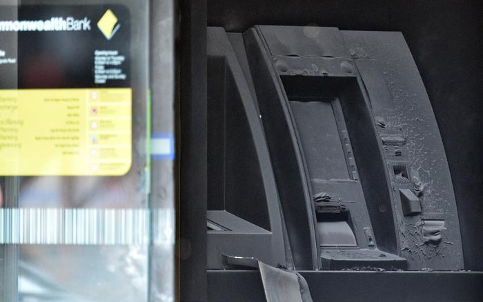 A fire damaged ATM is seen at the Commonwealth Bank Springvale in Melbourne, Friday, Nov. 18, 2016. More than two dozen people have been injured - six suffering serious burns - after a man allegedly set fire to a Commonwealth Bank branch in suburban Melbourne. (AAP Image/Julian Smith) NO ARCHIVING
