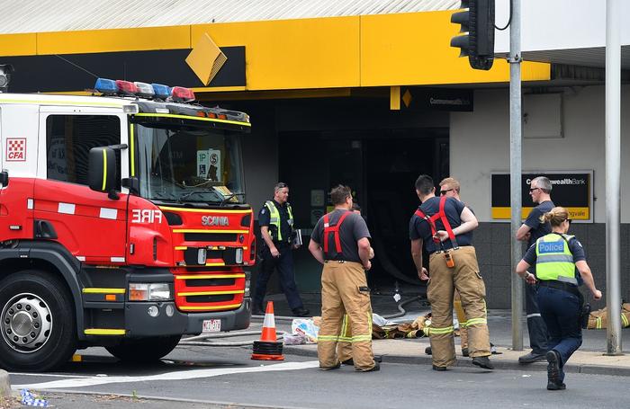 Emergency service workers are seen at the Commonwealth Bank in Melbourne, Friday, Nov. 18, 2016. More than two dozen people have been injured - six suffering serious burns - after a man allegedly set fire to a Commonwealth Bank branch in suburban Melbourne. (AAP Image/Julian Smith) NO ARCHIVING
