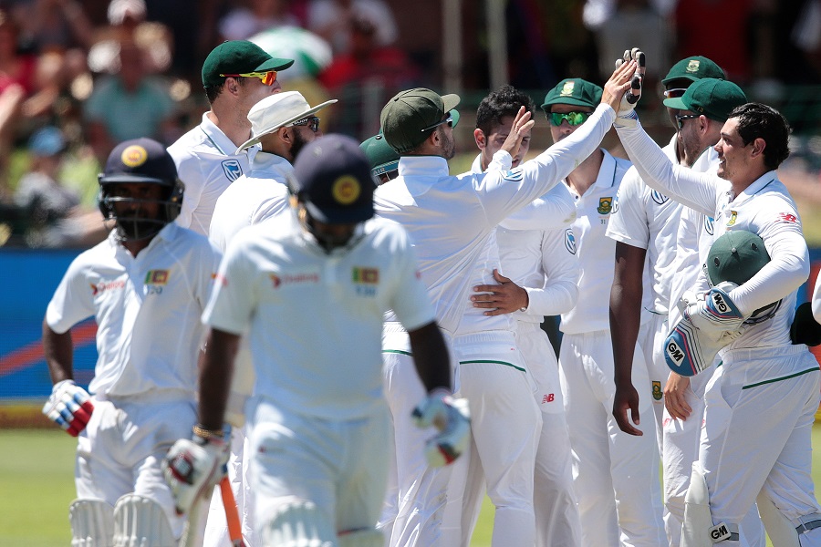 South African players celebrate the dismissal of Sri Lanka batsman Kusal Janith Perera (front) during the fourth day of the first Test between South Africa and Sri Lanka on December 29, 2016 at the Port Elizabeth cricket ground in Port Elizabeth.  / AFP PHOTO / GIANLUIGI GUERCIA