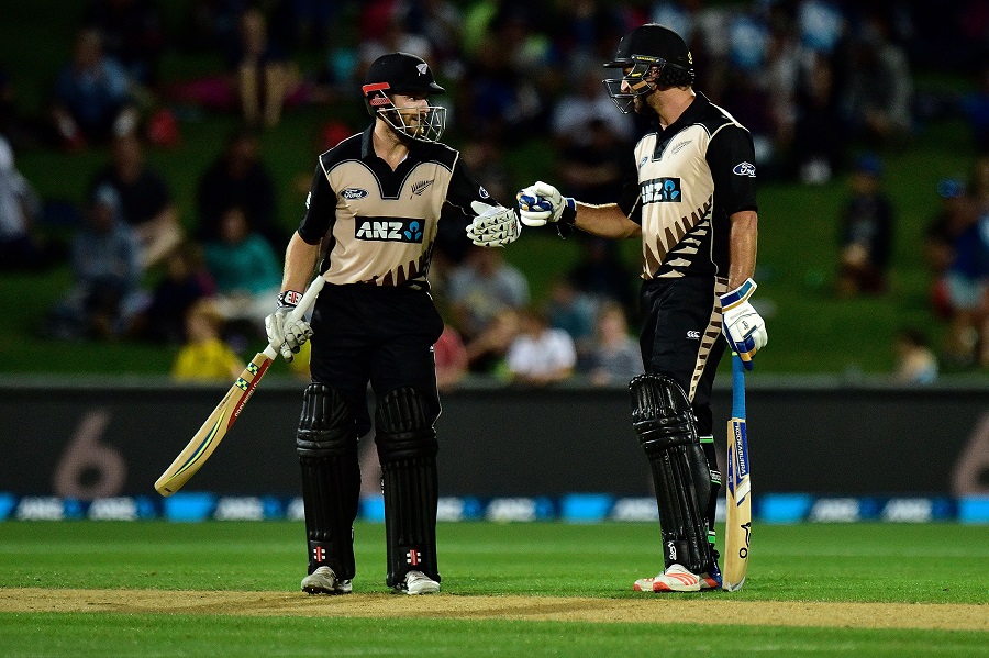 New Zealand's captain Kane Williamson (L) celebrates hitting a six with teammate Colin De Grandhomme during the first Twenty20 international cricket match between New Zealand and Bangladesh at McLean Park in Napier on January 3, 2017.  / AFP PHOTO / Marty Melville