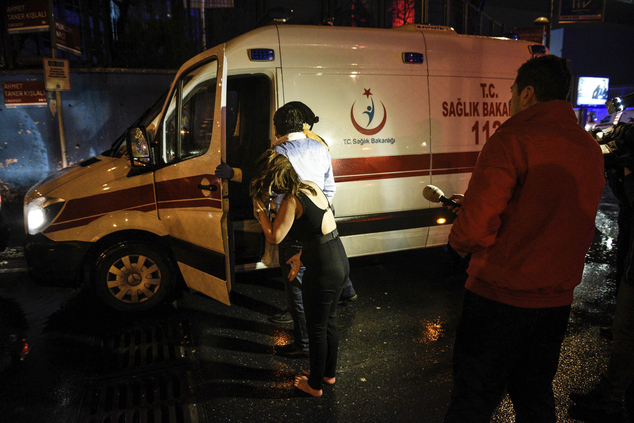 People talk to medics in an ambulance near the scene of an attack in Istanbul, early Sunday, Jan. 1, 2017. Turkey's state-run news agency said an armed assailant has opened fire at a nightclub in Istanbul during New Year's celebrations. (AP Photo)