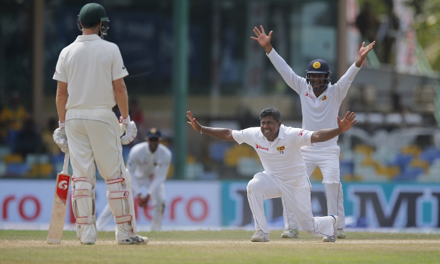 Sri Lanka's bowler Rangana Herath, right bottom, unsuccessfully appeals for the wicket of Australia's Mitchell Marsh during the third day of their third test cricket match in Colombo, Sri Lanka, Monday, Aug. 15, 2016. (AP Photo/Eranga Jayawardena)