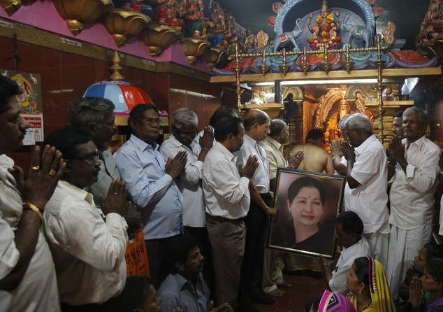 Supporters of Indian southern state of Tamil Nadu Chief Minister Jayalalithaa hold her photograph as they pray for her health at a temple in Mumbai, India, Monday, Dec. 5, 2016. Thousands of Jayalalitha supporters and well wishers across India prayed for her speedy recovery after she was readmitted to the hospital in Cheanni following a cardiac arrest on Sunday evening. (AP Photo/Rafiq Maqbool)